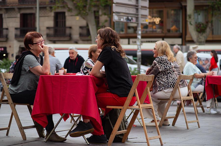 Dues desconegudes parlant en l'acte a Plaça Universitat de la Setmana contra la soledat no desitjada 2025