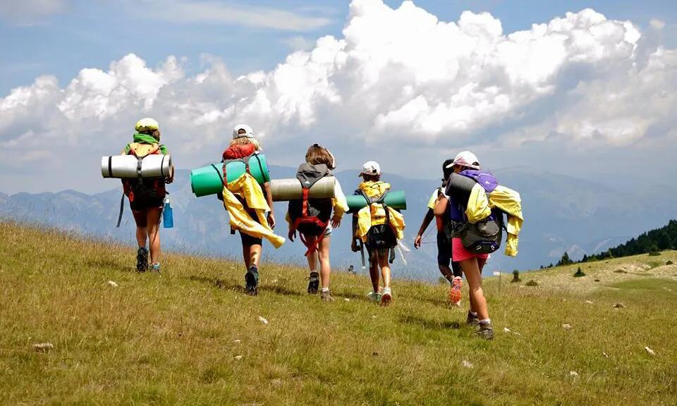Imatge de joves i infants d'acampada a la muntanya.