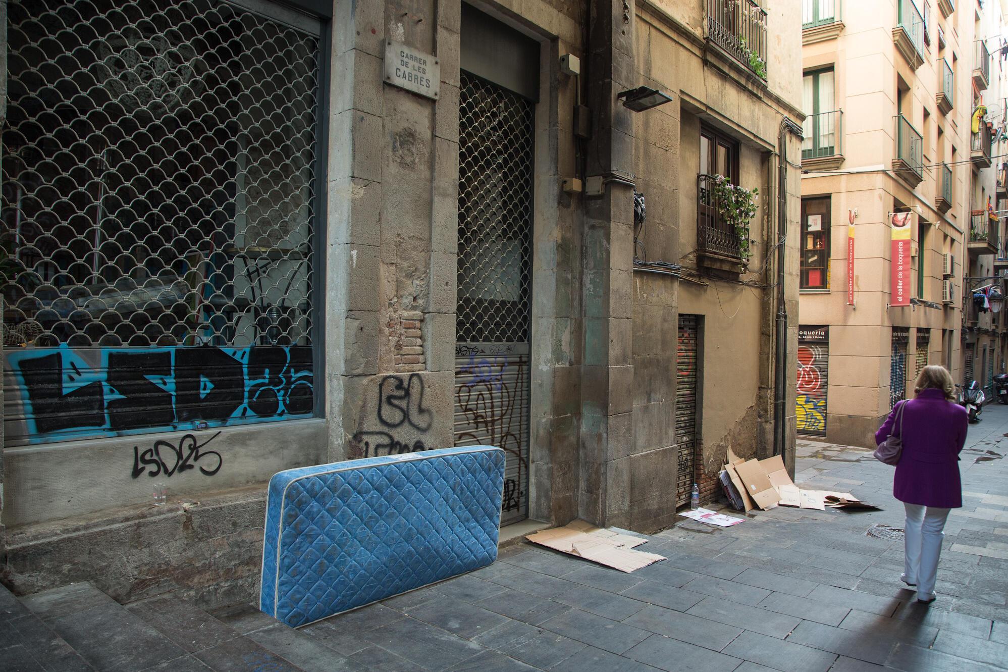 Imatge d'un matalàs i cartrons al carrer de persones sense llar