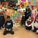 Imatge grup d'infants sostenint un mural que han treballat sobre el Dia dels Drets de la Infància