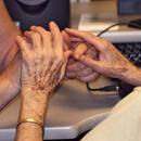 Imatge d'unes mans d'una persona gran i una altra persona en gest de cura