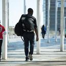 Imatge d'un jove i infants d'origen migrat caminant
