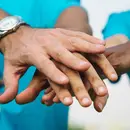 Persones voluntàries juntant mans