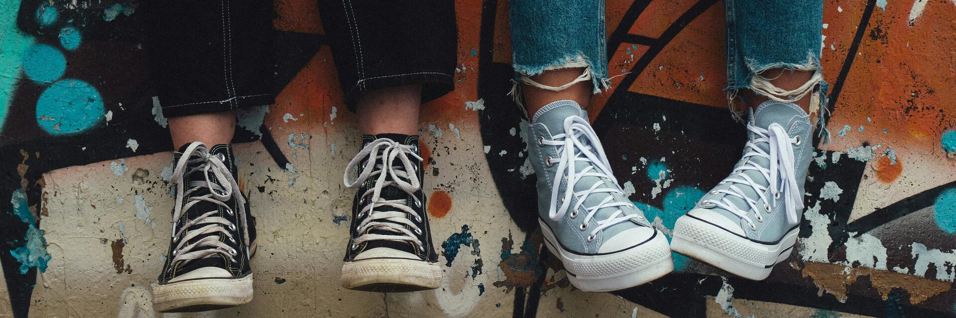 Imatge de les cames i sabates de dos adolescents