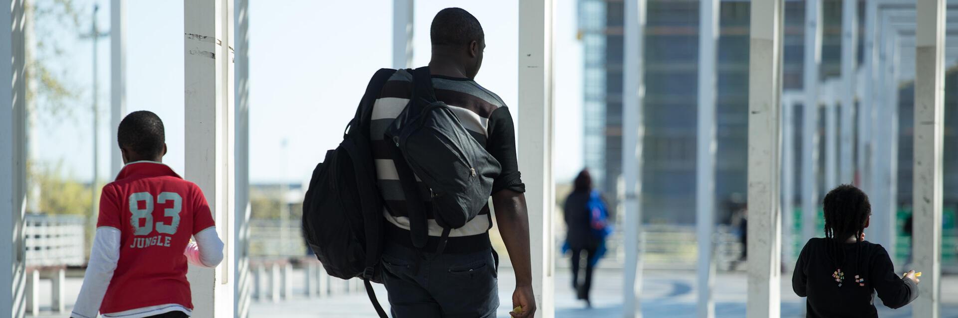 Imatge d'una família d'origen migrat caminant al carrer