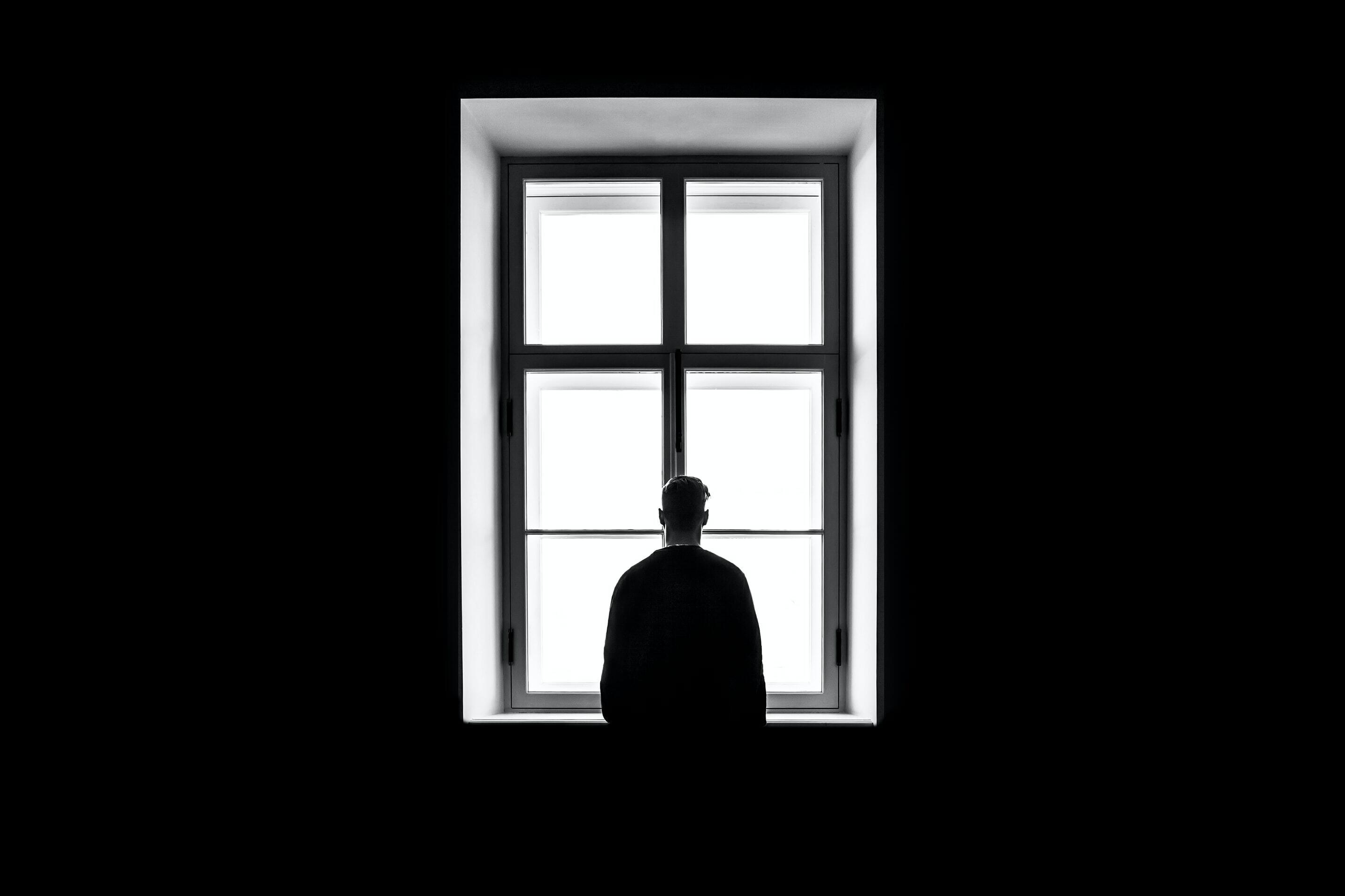 Imatge persona mirant a través d'una finestra