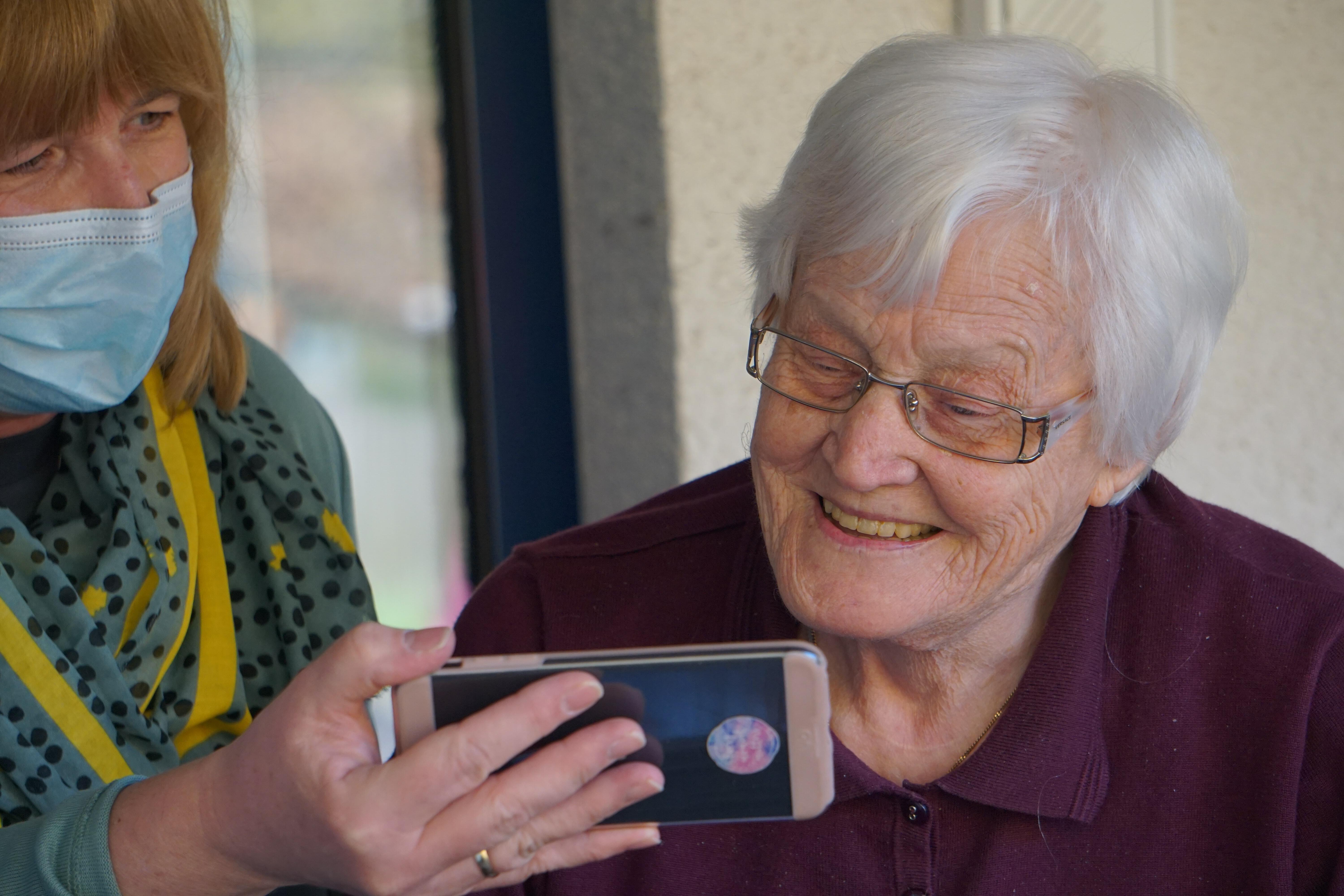 Imatge d'una persona gran amb el seu familiar en una vídeoconferència