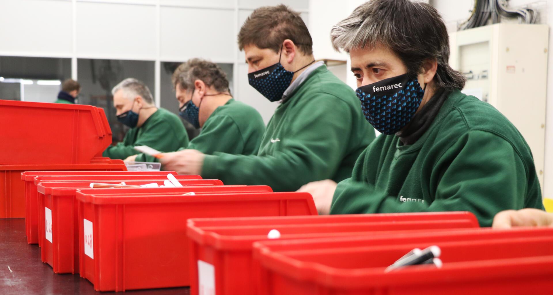 Un grup de cinc treballadors endreçant unes caixes