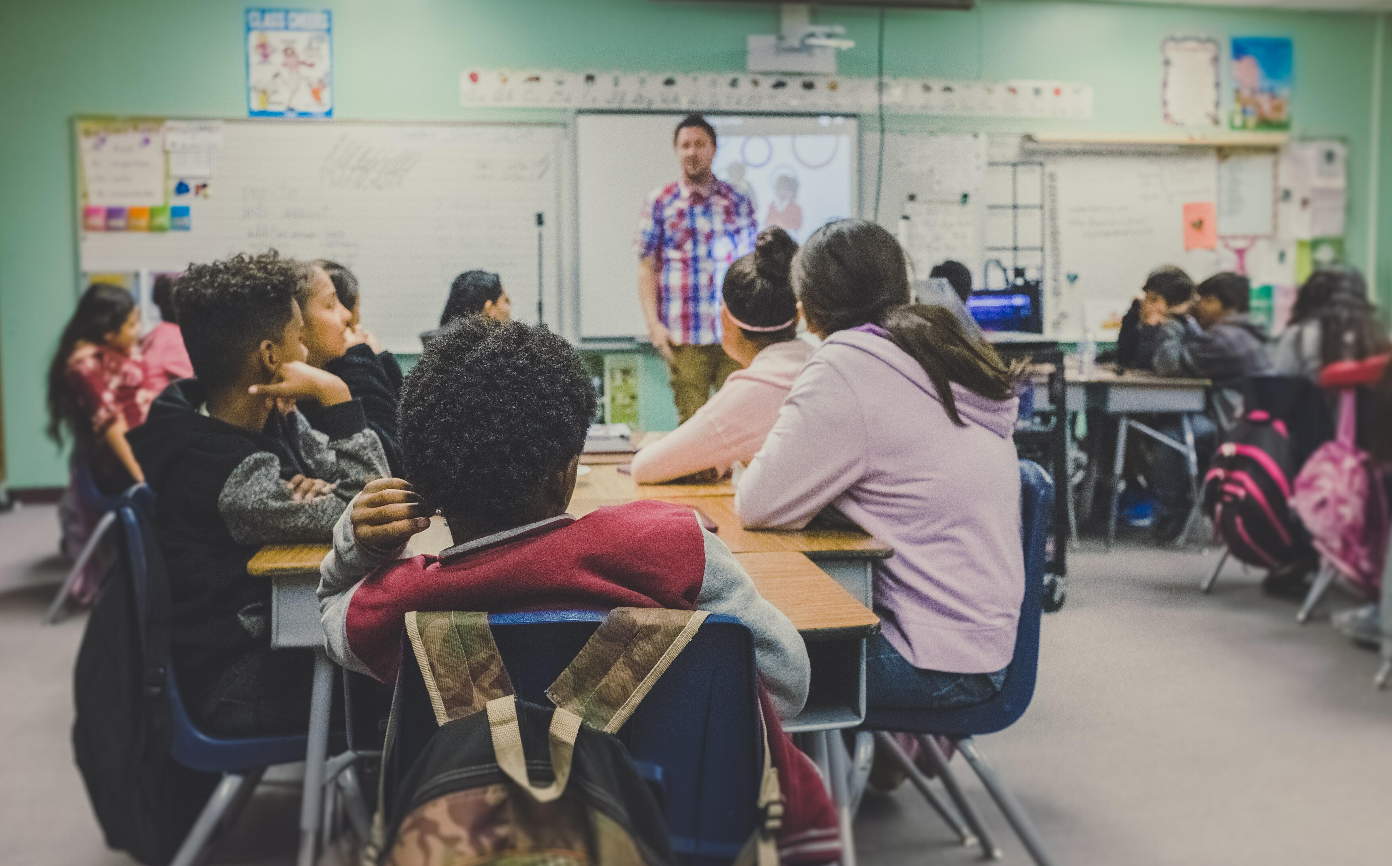 Grup d'alumnes escoltant el seu professor durant una classe