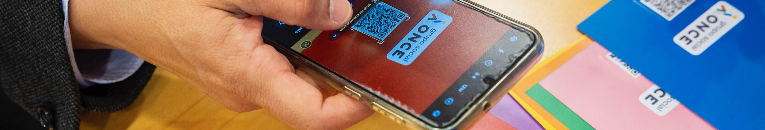 Imatge persona escanejant un QR amb el mòbil 