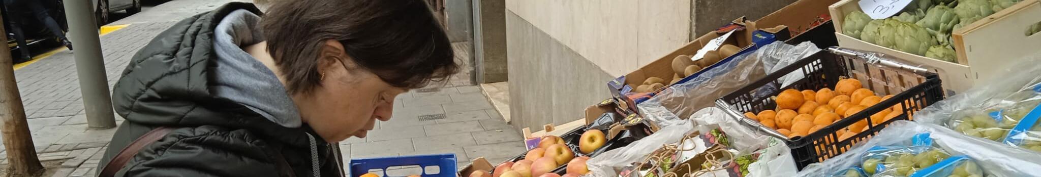 Dona amb discapacitat intel·lectual comprant fruita