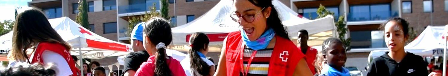 Imatge de joves voluntàries de Creu Roja Joventut en una activitat amb infants