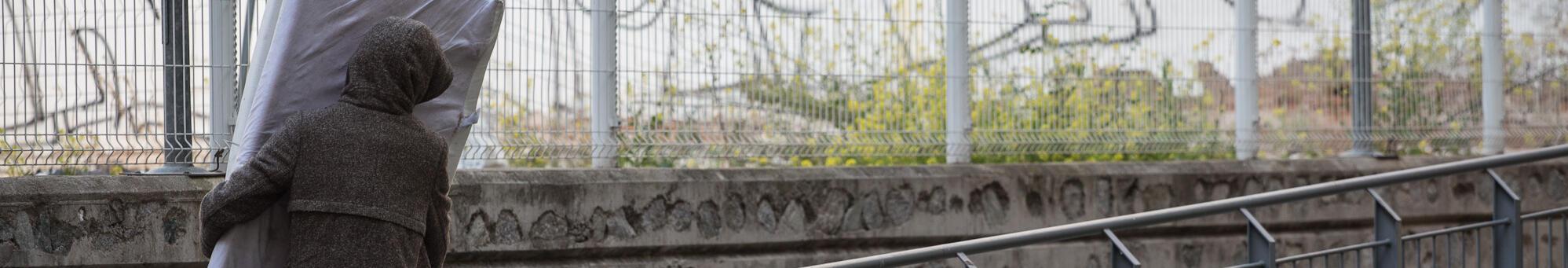 Imatge d'una persona transportant un matalàs al carrer