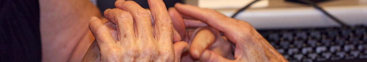 Imatge d'unes mans d'una persona gran i una altra persona en gest de cura