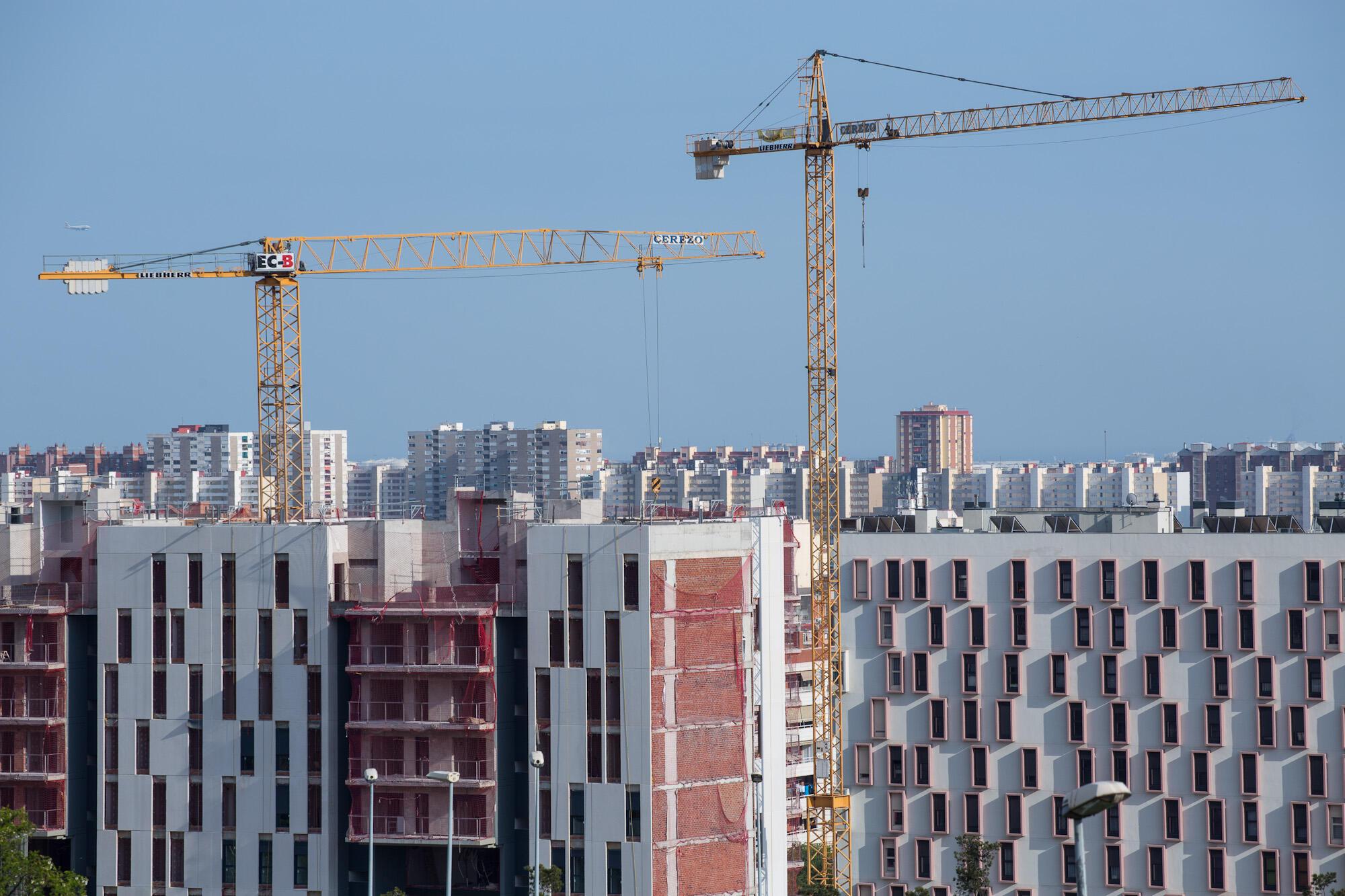 Imatge grues de construcció enmig d'edificis