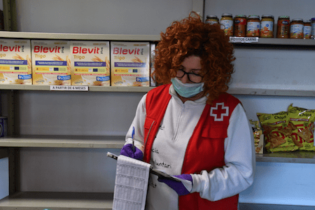 Treballadora de Creu Roja fa inventari d'aliments en un magatzem.