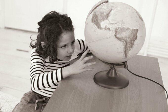 Imatge d'una nena mirant una bola del món