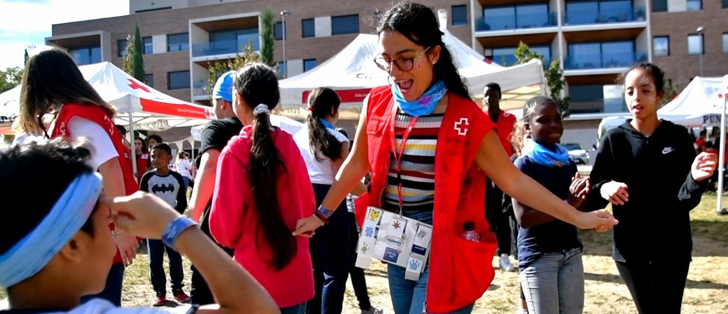 Imatge de joves voluntàries de Creu Roja Joventut en una activitat amb infants