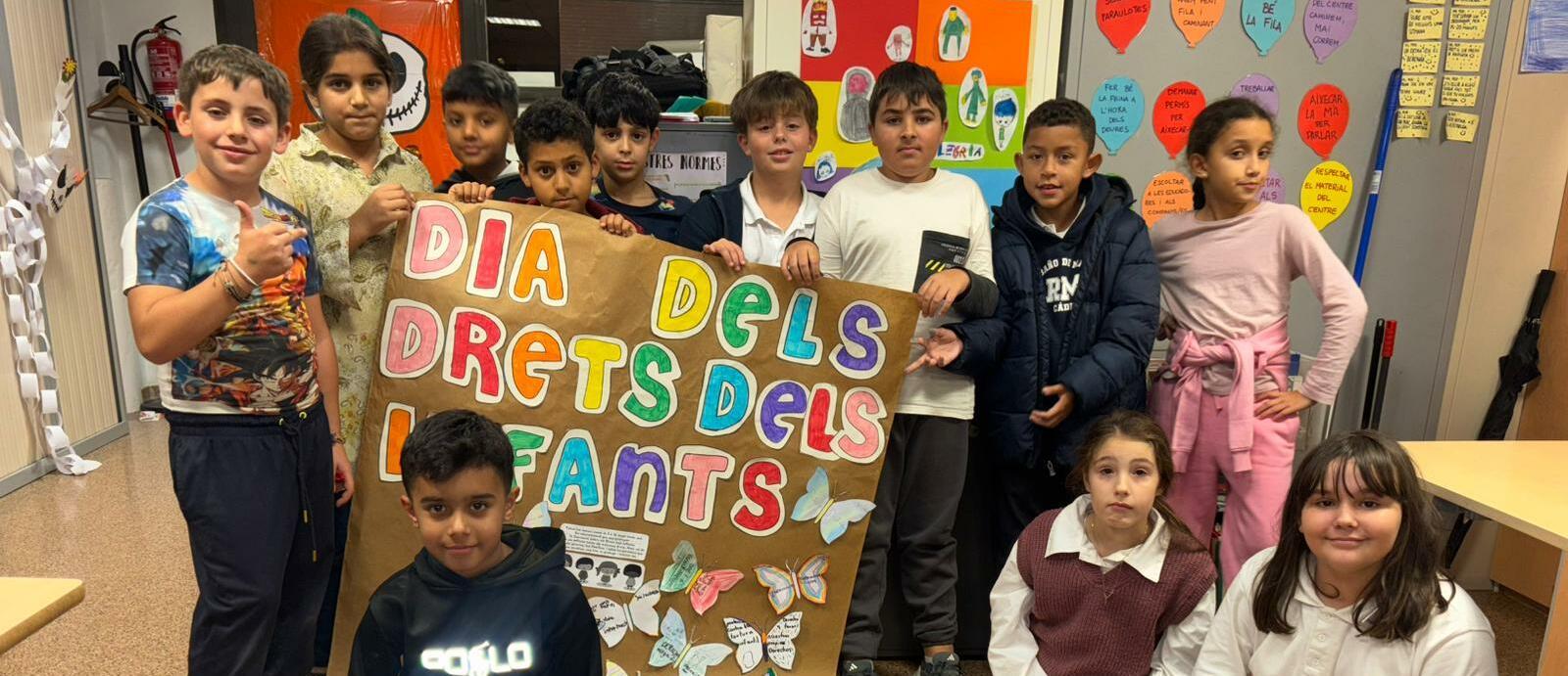 Imatge grup d'infants sostenint un mural que han treballat sobre el Dia dels Drets de la Infància