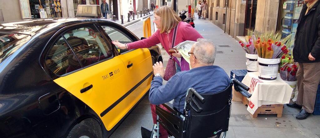 Imatge d'una persona en cadira de rodes agafant un taxi
