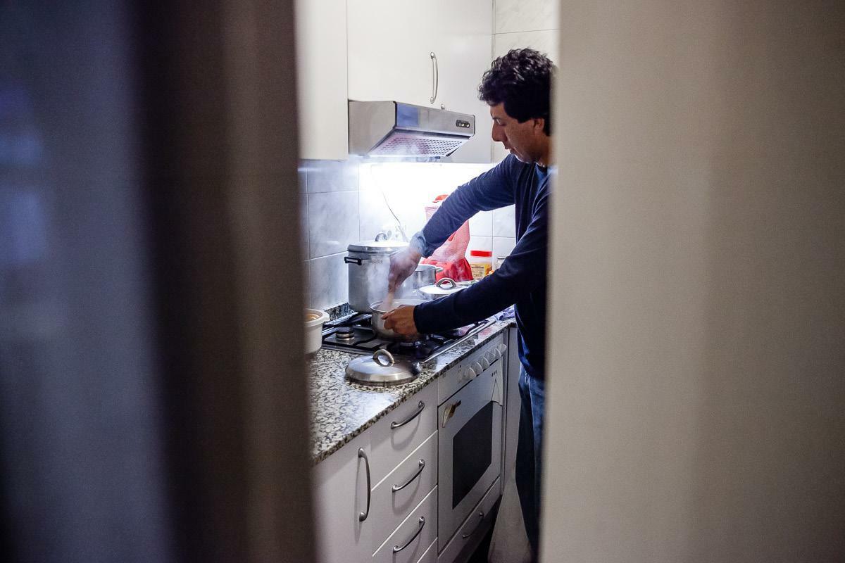Imatge d'un home atès per Càritas Catalunya a la cuina de casa seva