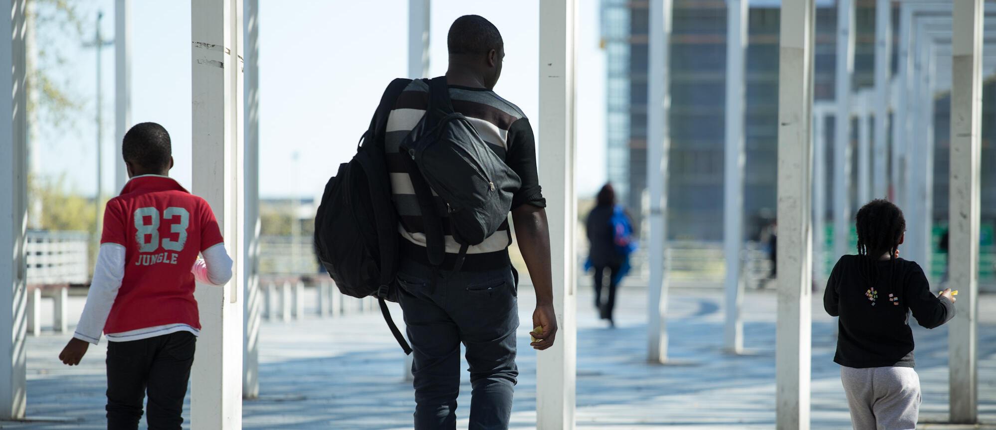Imatge d'una família d'origen migrat caminant al carrer