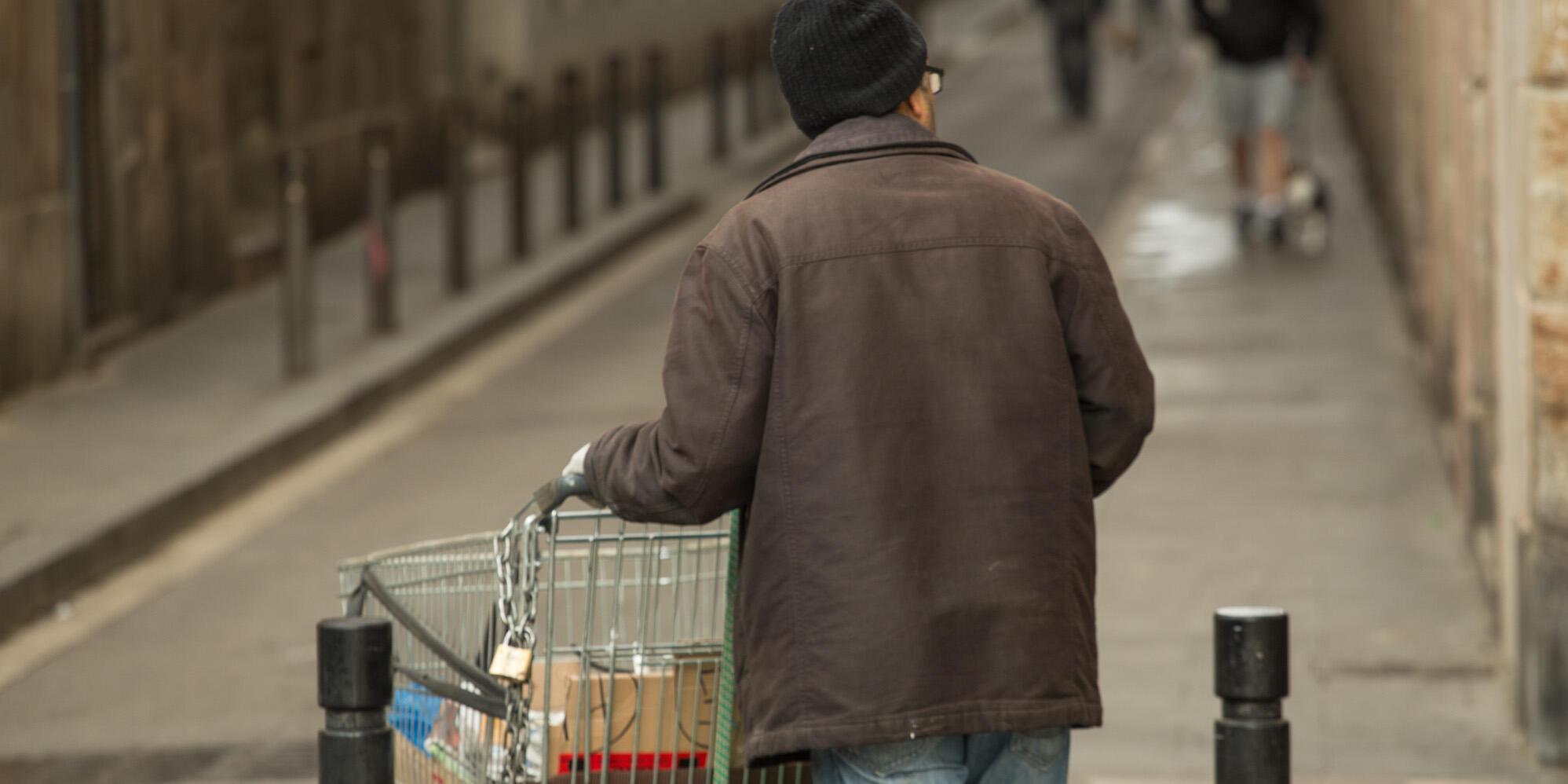 Imatge persona sense llar amb un carretó de supermercat