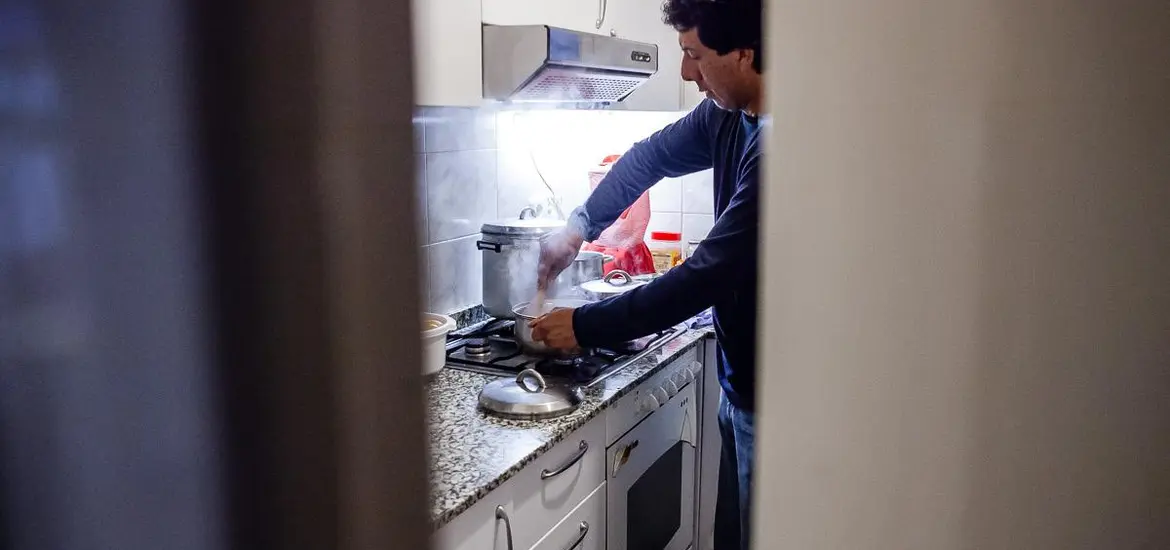 Imatge persona atesa per Càritas a la cuina de la seva llar