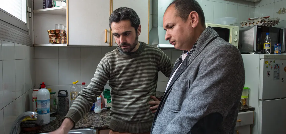 Imatge persones amb discapacitat a la cuina de casa seva amb una persona de suport